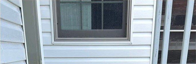 The same siding and window trim clean and white after washing