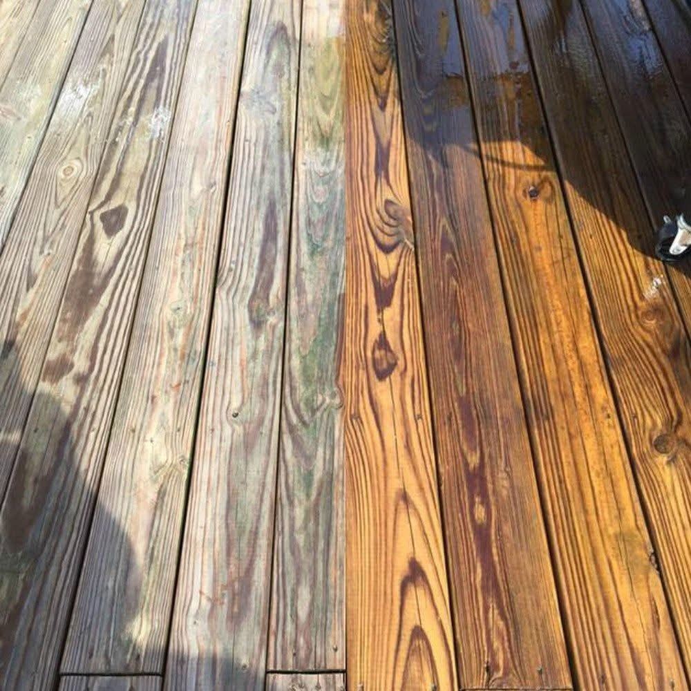 Pressure-treated deck boards, the left half still gray and the right half washed to fresh wood