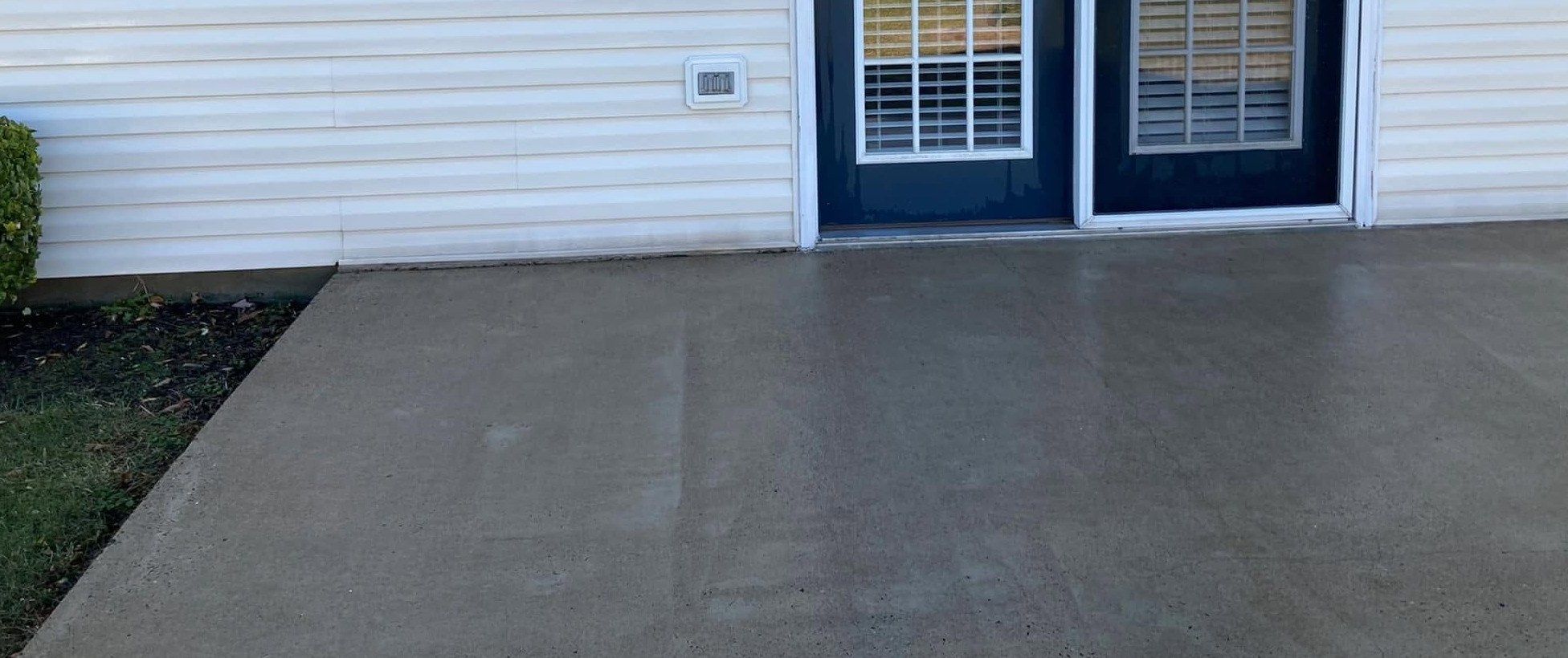 The same concrete patio washed to an even light gray