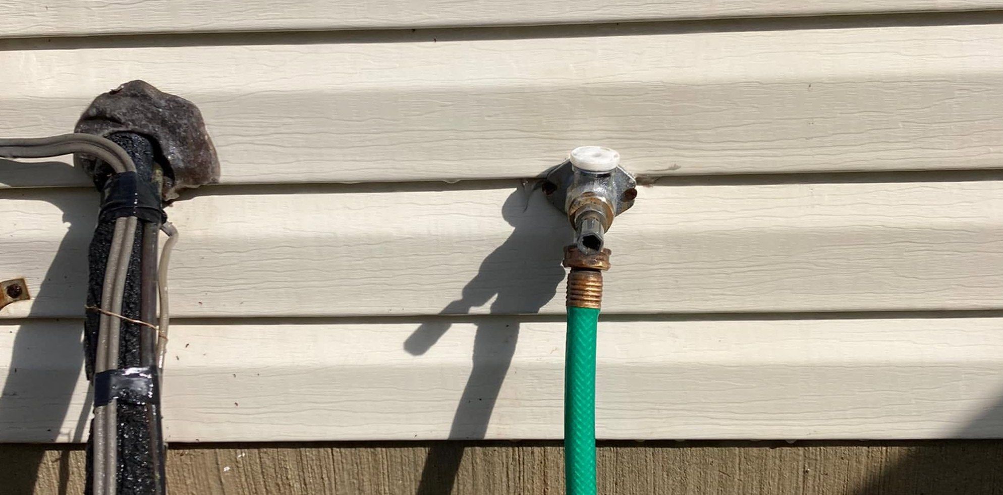 The same siding by the spigot with the rust stains removed