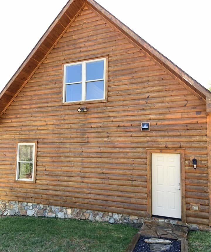 The same log gable with a white door, logs clean and even after washing