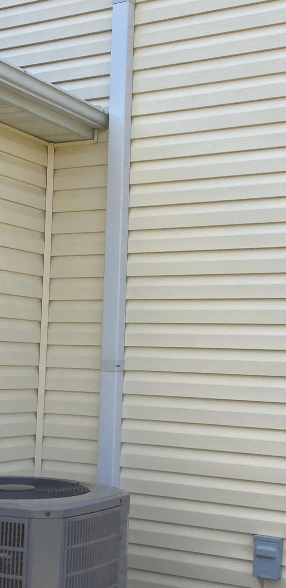 The same siding and downspout clean after soft washing