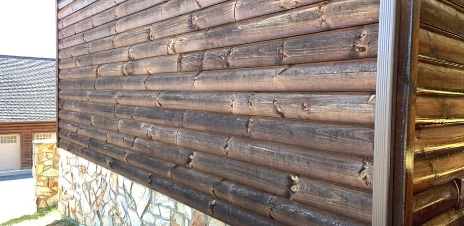 Gray weathered log siding over a stone foundation