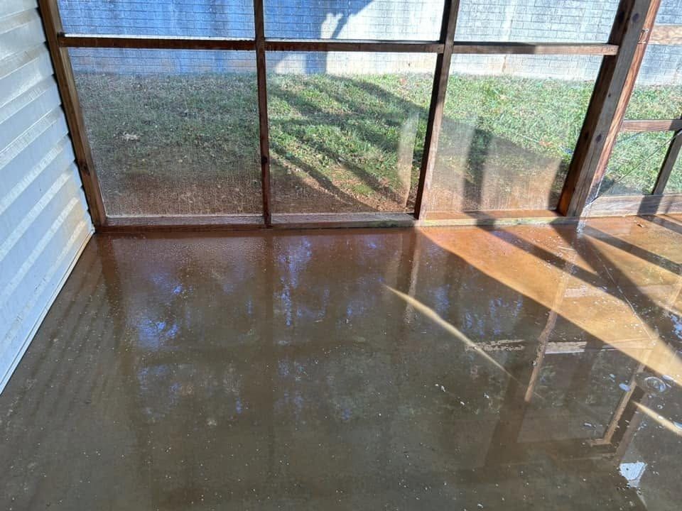 Screened porch concrete floor covered in rinse water during cleaning