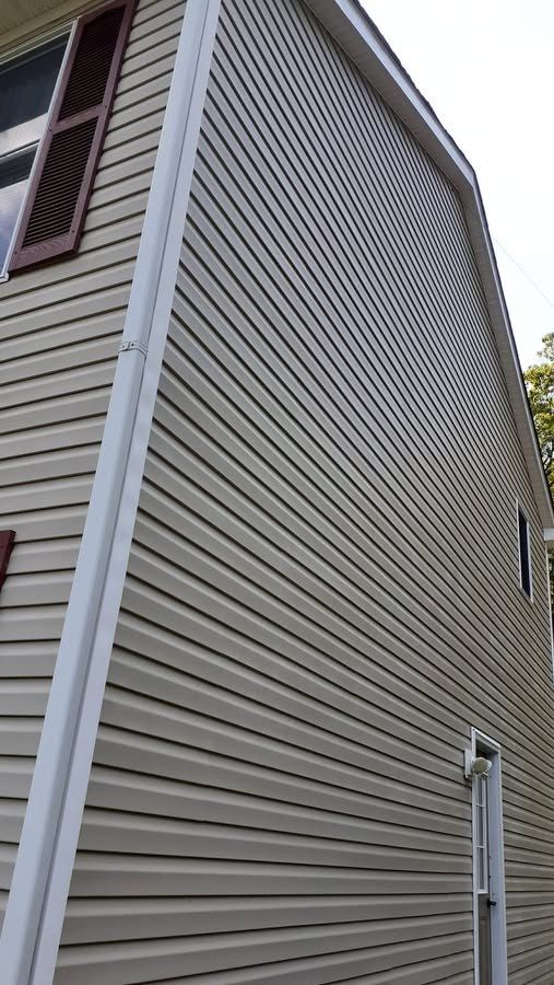 Clean tan vinyl siding on a tall gable wall