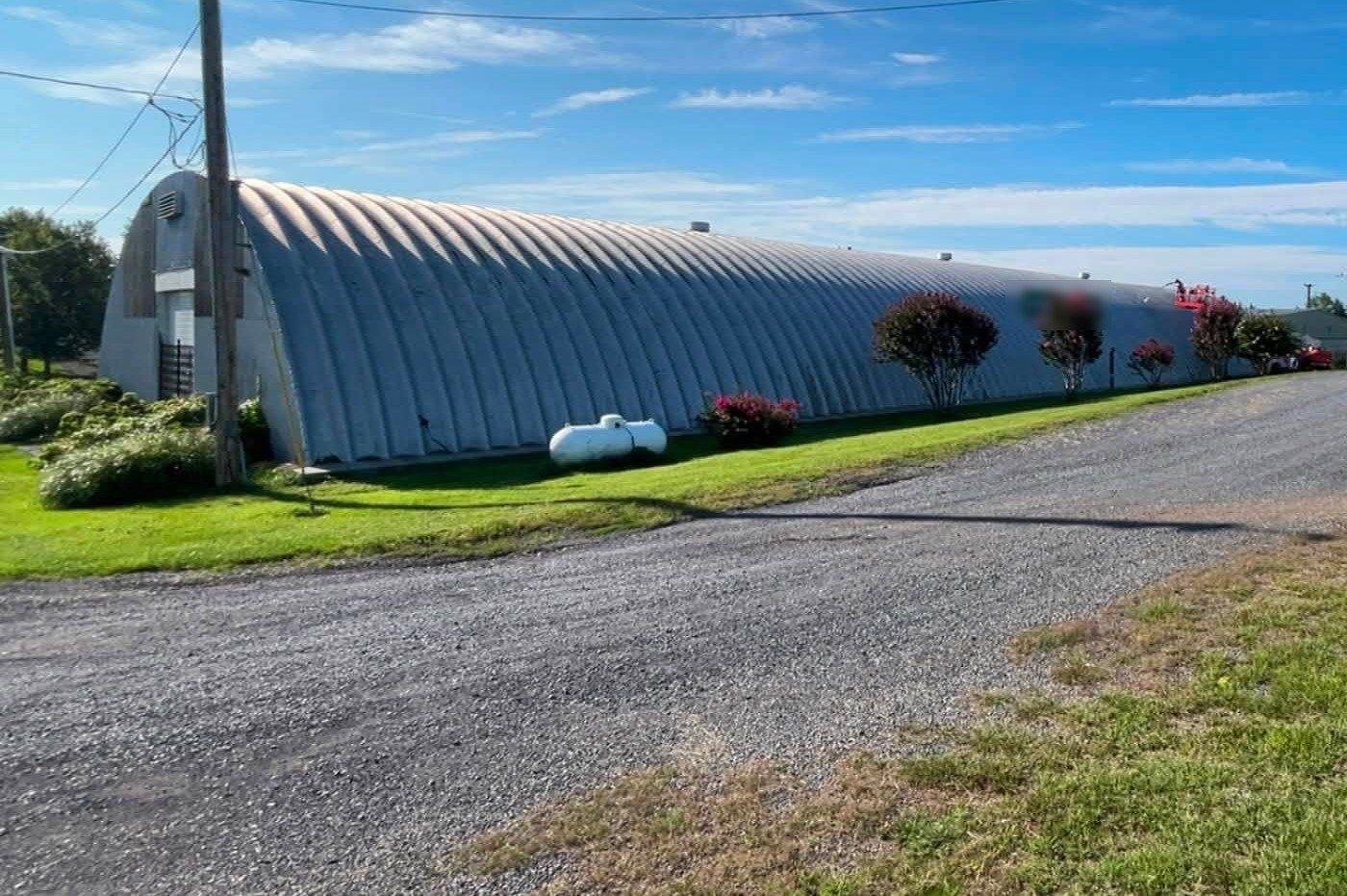 Long metal building with a boom lift washing the far end