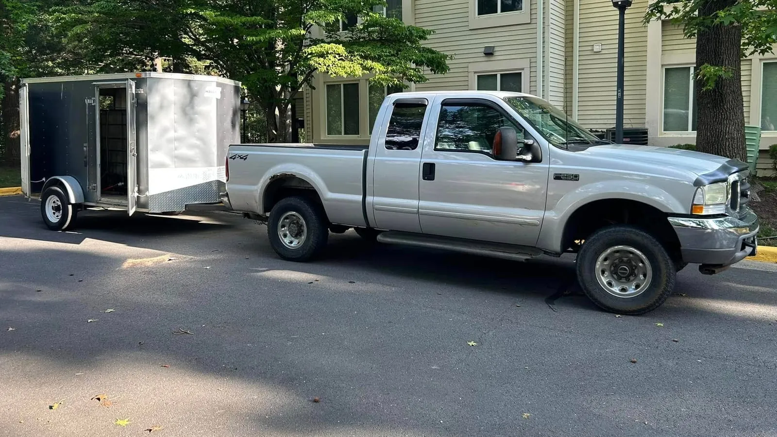 Chem-Clean's silver pickup towing the enclosed trailer that carries the water tank