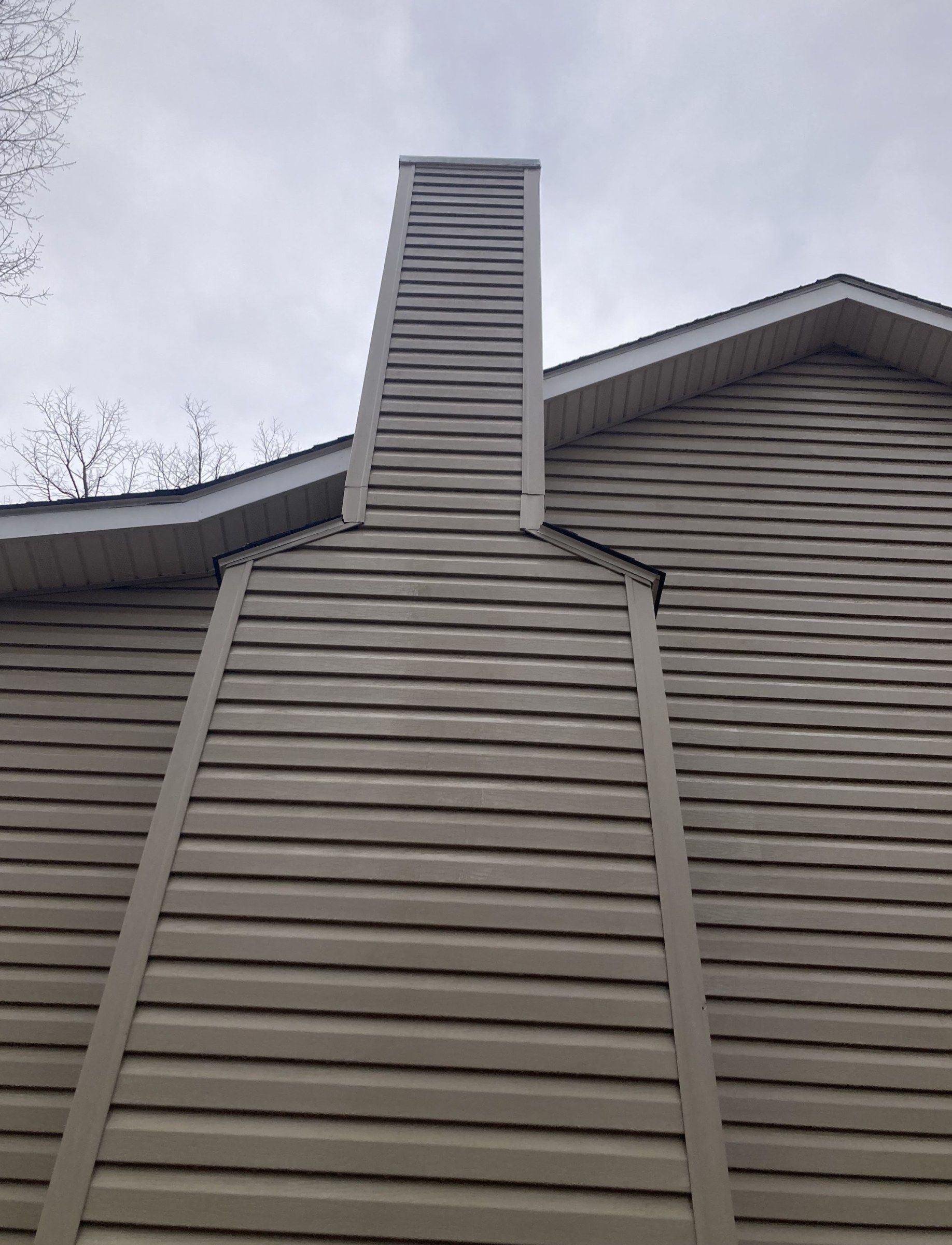 The same chimney chase after washing, even tan siding