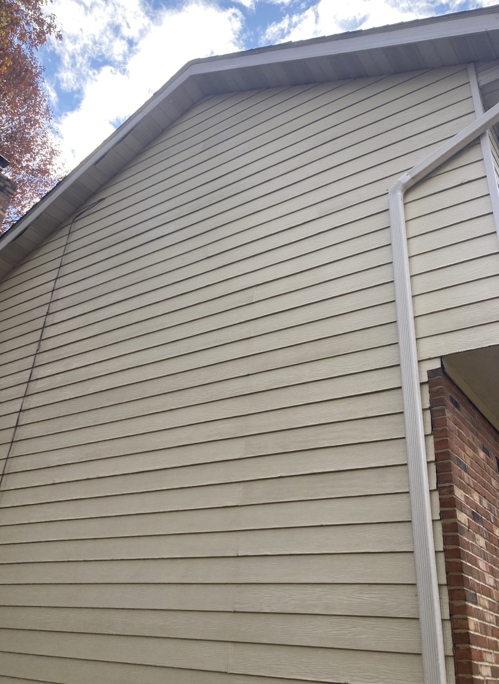 The same siding after washing, clean and even beside the brick corner