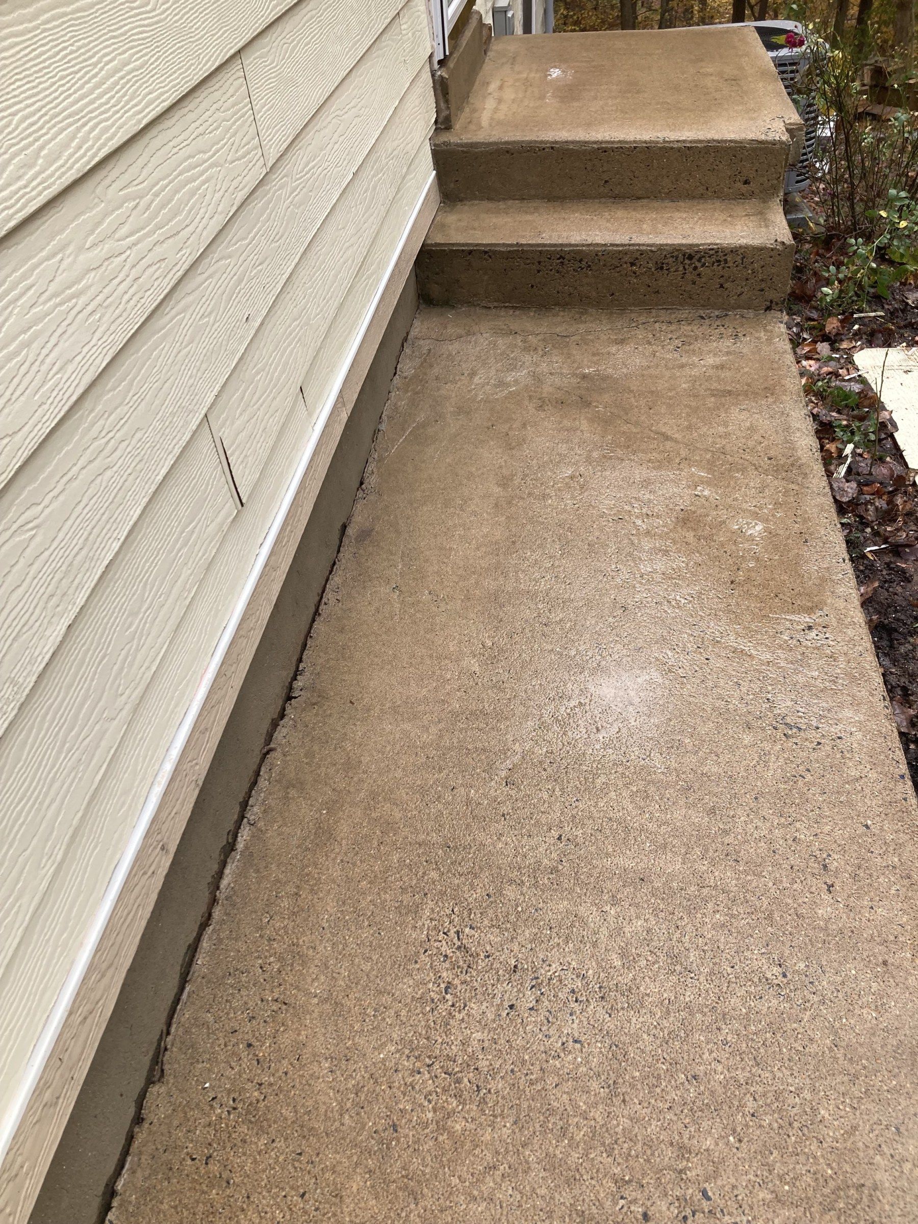 The same concrete walkway and steps clean and light tan after pressure washing